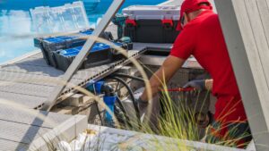 Un técnico realizando el mantenimiento del motor de una piscina